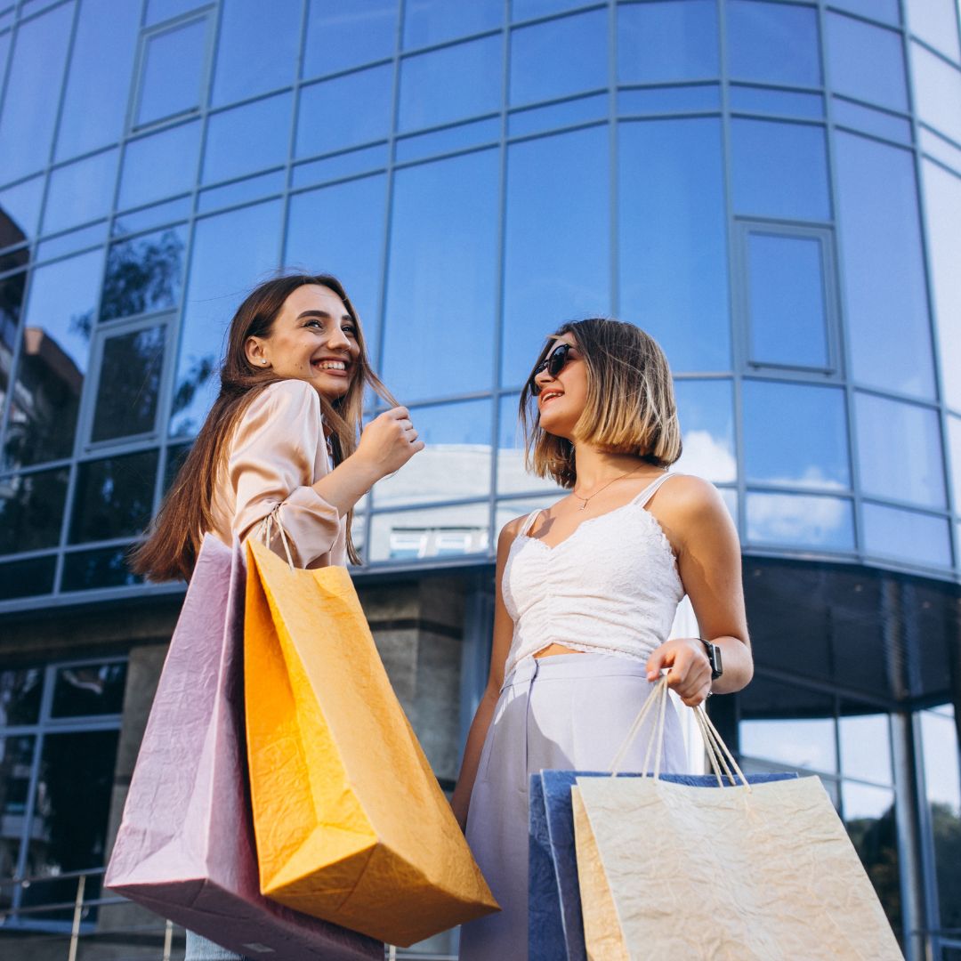 Due donne con shopper in mano che fanno shopping