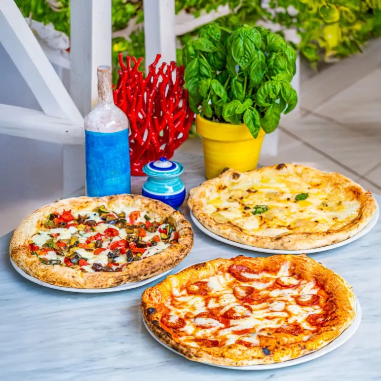 Tre pizze napoletane sopra un tavolo